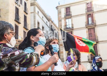 Barcellona, Catalogna, Spagna. 18 agosto 2021. Il manifestante è visto parlare in un microfono accanto ad una bandiera afgana.circa cinquecento persone hanno dimostrato a Barcellona in solidarietà con le ragazze e le donne dell'Afghanistan e in difesa dei loro diritti sotto lo slogan ''Afghanistan: Per una vita con dignità e libertà' (Credit Image: © Thiago Prudencio/DAX tramite CAVO ZUMA Press) Foto Stock