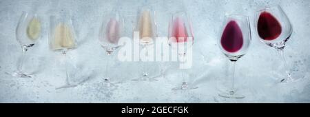 Panorama del vino con molti bicchieri di vino rosa, rosso e bianco, in alto piatto scatto. Varietà di colori del vino Foto Stock