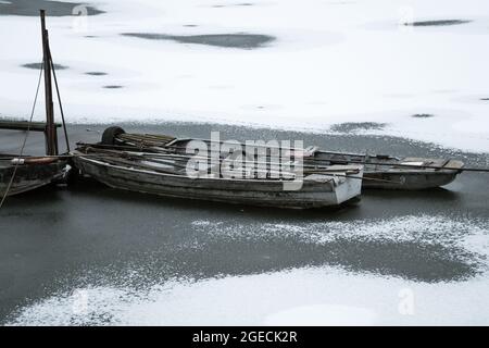 piccole imbarcazioni in acqua ghiacciata durante l'inverno in molo Foto Stock