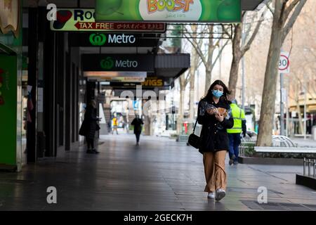 Melbourne, Australia, 23 luglio 2020. La gente vedette indossare maschere a piedi vicino strade vuote a Melbourne, come il Premier vittoriano confermato 403 nuovi casi di coronavirus durante la notte. Mercoledì 22 luglio, alle ore 11.59, alle persone che vivono nella metropoli di Melbourne e Mitchell Shire, sarà ora richiesto di indossare una copertura facciale quando si lascia casa, a seguito di un aumento preoccupante dei casi di coronavirus negli ultimi giorni. L'ammenda per non indossare una copertura del viso sarà di 200 dollari. Credit: Dave Hewison/Speed Media/Alamy Live News Foto Stock