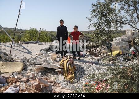 Balashun, Siria. 19 agosto 2021. I bambini ispezionano le macerie di una casa dopo un missile che lo ha preso di mira nella città di Balashun nella regione di Jabal al-Zawiya (montagna Zawiya). Credit: ANAS Alkharboutli/dpa/Alamy Live News Foto Stock