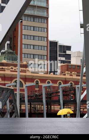 Melbourne, Australia, 14 agosto 2020. Un uomo che indossa una maschera e si allontana dalla pioggia sotto un ombrello attraversa il ponte Evan Walker durante il COVID-19 a Melbourne, Australia. Victoria ha registrato 14 decessi correlati a COVID, tra cui un 20 anni, che hanno segnato il più giovane a morire di Coronavirus in Australia, e altri 372 nuovi casi durante la notte. (Foto di Dave Hewison/Speed Media) Credit: Dave Hewison/Speed Media/Alamy Live News Foto Stock