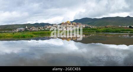 Songzanlin tibetano monastero buddista si riflette nel lago sacro, Shangri-La, nella provincia dello Yunnan in Cina Foto Stock