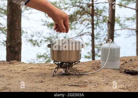 Cibi turistici in attività all'aperto. Cibo in bowler nella foresta verde. Campeggio alimentare fare. Foto Stock