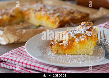 Un pezzo di torta con mandorle e frutta su un piatto Foto Stock