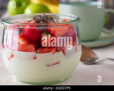 Yogurt fatto in casa con fragole fresche e semi di chia su un tavolo per la colazione. Primo piano e vista isolata Foto Stock