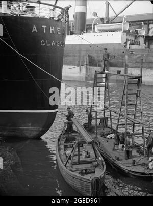 GLASGOW, SCOZIA, Regno Unito - 1937 - Glasgow, Scozia. Dipingere la poppa della S.S. Athenia. Questo liner fu la prima nave affondata nella seconda guerra mondiale b Foto Stock