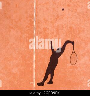 Ombra di un giocatore professionista di tennis che esegue potente primo servire con un salto rimbalzo Foto Stock