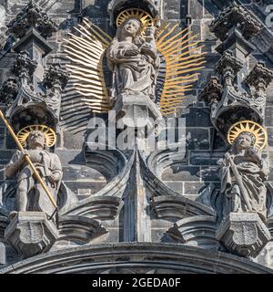 Le figure della parete superiore dei cavalieri e una santa donna con un bambino nella torre della facciata principale e lato dell'orologio della cattedrale cattolica a Magdeburg, Germania, cl Foto Stock