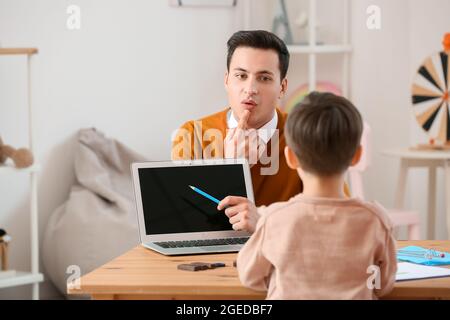 Logopedista lavora con little boy in office Foto Stock