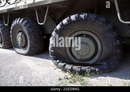 Un pneumatico sgonfio su un veicolo voyengoy. Vecchio portaerei armati sovietici imbottiti militari Foto Stock