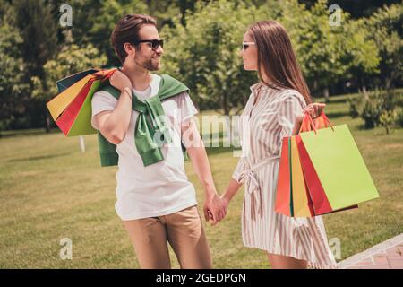 Ritratto foto coppia a piedi con pacchetti dal centro commerciale dopo la vendita in estate Foto Stock