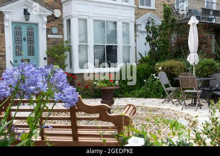 Casa in stile georgiano con giardino costiero o balneare e agapanthus in fiore sul lungomare di Cowes, Isola di Wight, Inghilterra, Regno Unito Foto Stock