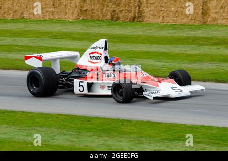 McLaren M23 F1, Grand Prix racing car che sale sulla pista di salita al Goodwood Festival of Speed Motor Racing evento 2014 Foto Stock