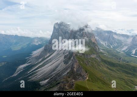 Cima alpina coperta di nuvole. Veduta aerea della catena montuosa Seceda nelle Dolomiti, Alpi Italiane. Foto Stock