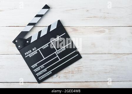 Classico clapper film nero su sfondo bianco di legno Foto Stock