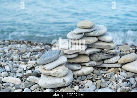 Accatastato figura di pietra sulla spiaggia al mattino Foto Stock