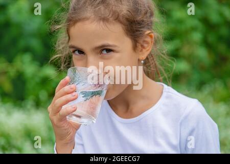 Bambino beve acqua da un bicchiere Foto stock - Alamy