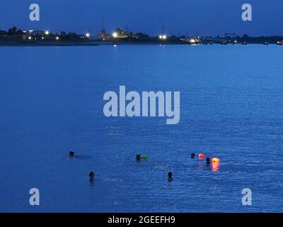 Sheerness, Kent, Regno Unito. 19 agosto 2021. Regno Unito Meteo: Nuotatori notturni al tramonto a Sheerness, Kent. Credit: James Bell/Alamy Live News Foto Stock