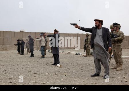 La direzione nazionale afghana dei dipendenti della sicurezza e i poliziotti in uniforme afghani, di stanza nella città di Khost, sparano le pistole M-9 Beretta su una piccola gamma di armi a Camp Parsa, provincia di Khowst, Afghanistan, 30 gennaio 2013. I soldati dell'esercito degli Stati Uniti assegnati alle forze di sicurezza consigliano e assistono il Team 28, Task Force 3/101, pianificarono la gamma e assistirono l'AUP e NDS con la pratica sicura con le loro armi. (STATI UNITI Foto dell'esercito di Sgt. Kimberly Trumbull / rilasciato) Foto Stock