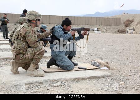 Un poliziotto afghano in uniforme, di stanza nella città di Khost, spara il suo fucile AK-47 su una piccola gamma di armi a Camp Parsa, provincia di Khowst, Afghanistan, 30 gennaio 2013. I soldati dell'esercito degli Stati Uniti assegnati alle forze di sicurezza consigliano e assistono il Team 28, Task Force 3/101, progettarono la gamma e assistirono l'AUP con la pratica sicura con le loro armi. (STATI UNITI Foto dell'esercito di Sgt. Kimberly Trumbull / rilasciato) Foto Stock