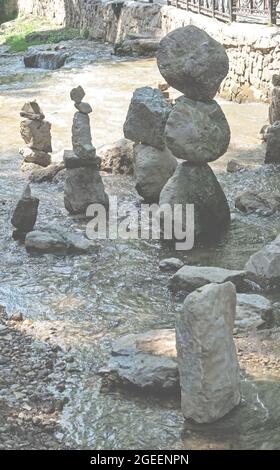 Scultura di pietre equilibranti in pietra dal fiume sullo sfondo. Concetto Zen Foto Stock