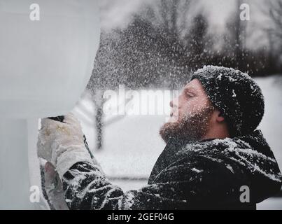 Carver professionale per ghiaccio che scolpisce blocco di ghiaccio Foto Stock