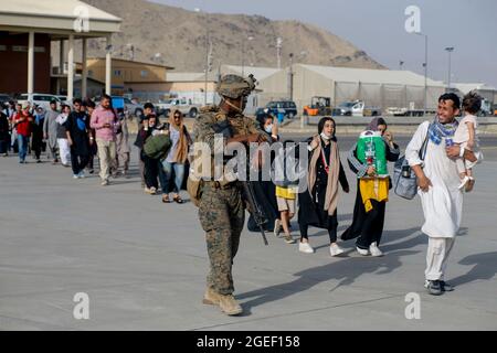 210818-M-JM820-1162 AEROPORTO INTERNAZIONALE DI HAMID KARZAI, Afghanistan (18 agosto 2021) – i Marines statunitensi assegnati alla 24a unità di spedizione marittima accompagnano gli sfollati durante un'evacuazione all'Aeroporto Internazionale di Hamid Karzai, Afghanistan, 18 agosto. I membri del servizio degli Stati Uniti stanno assistendo il Dipartimento di Stato con un ordinato prelievo di personale designato in Afghanistan. (STATI UNITI Marine Corps foto di Lance CPL. Nicholas Guevara) Foto Stock