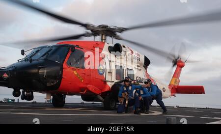 I membri della Guardia Costiera a bordo della Cutter Munro della Guardia Costiera conducono operazioni di tiedown con un MH-60J Jayhawk al largo della costa di San Diego, California, 23 luglio 2021. La Cutter Munro della Guardia Costiera ha condotto operazioni di volo per mantenere le competenze operative. (STATI UNITI Corpo marino Foto di Sgt. Kevin G. Rivas Foto Stock