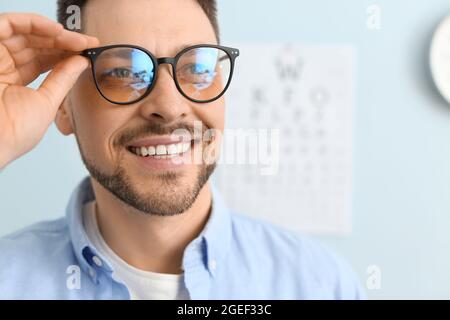 Uomo con nuovi occhiali in visita oftalmologo in clinica Foto Stock