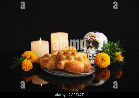 Pane dei morti e cranio dipinto su sfondo scuro. Celebrazione della Giornata dei morti del Messico (El dia de Muertos) Foto Stock