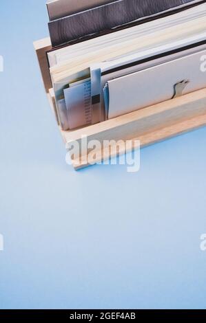 Colpo verticale di una scatola di legno riempita con carta su una superficie blu Foto Stock