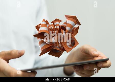 Rendering in 3D di coni di traffico fluttuanti rispetto al concetto di costruzione di un cantiere per le mani di un uomo d'affari Foto Stock