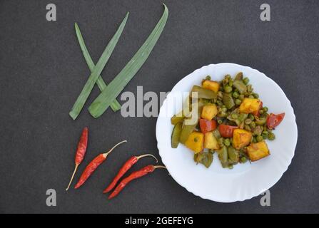 Piatto di paneer matar mix di ricetta veg (cibo indiano) e peperoncino rosso su sfondo nero Foto Stock