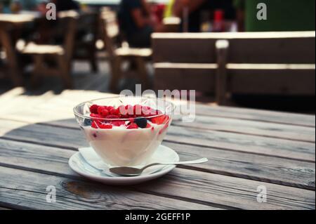 Ciotola con frutti di bosco freschi su tavolo di legno Foto Stock