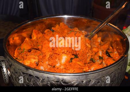 Idli fritto in una grande pentola è decorato con spezie fritte. Foto Stock