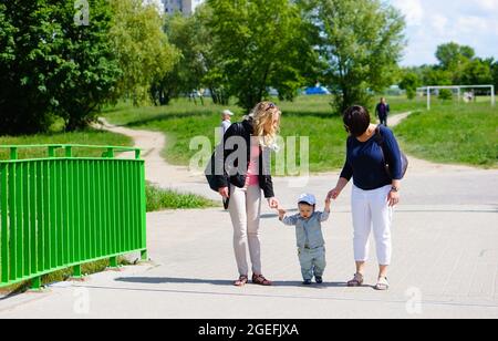 POZNAN, POLONIA - 12 settembre 2015: Due donne che tengono le mani con il bambino e camminano Foto Stock