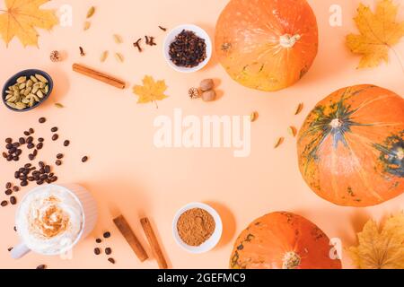 Composizione piatta di latte di spezie di zucca autunnale con ingredienti e zucche intere su sfondo arancione chiaro Foto Stock