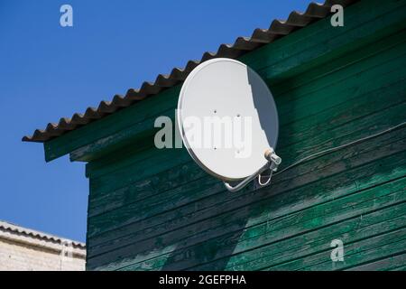 Russia. Regione di Kaluga. Telecomunicazioni. Antenne TV satellitare sulla facciata di un edificio residenziale. Foto Stock