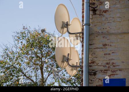 Russia. Regione di Kaluga. Telecomunicazioni. Antenne TV satellitare sulla facciata di un edificio residenziale. Foto Stock