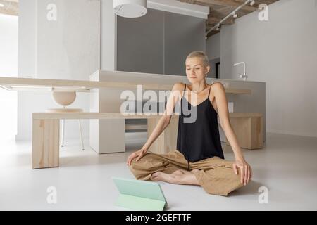 La donna a praticare yoga a casa Foto Stock