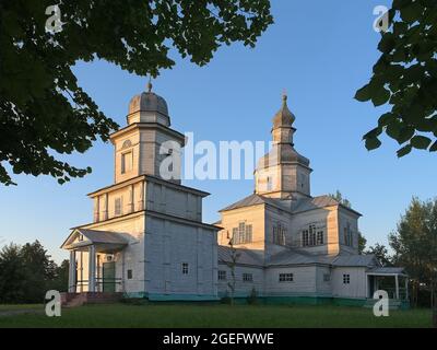Vecchia chiesa rurale in legno con campanile al tramonto Foto Stock