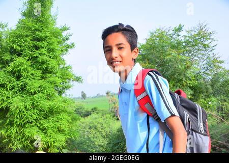 Borsa scuola appesa bambino rurale indiano in uniforme scolastica Foto Stock