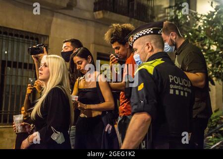 Barcellona, Catalogna, Spagna. 19 ago 2021. La polizia è vista sgombrare la folla di persone.la Corte superiore di Giustizia della Catalogna (TSJC) ha determinato questo Giovedi, 19 agosto, la fine del coprifuoco a Barcellona, coincidendo con la settimana in cui si celebra la tradizionale festa del quartiere Gracia. Le frequenti folle di persone che bevono per strada sono durate tutta la notte anche se in alcuni punti la polizia ha effettuato sfratti. (Credit Image: © Thiago Prudencio/DAX via ZUMA Press Wire) Foto Stock