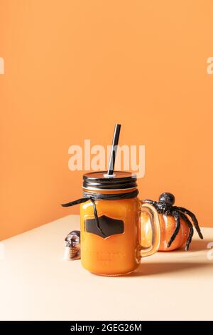 Halloween cocktail di zucche decorate piccoli ragni giocattolo su sfondo arancione. Primo piano. Formato verticale. Delizie per feste. Foto Stock