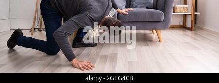 Chiave persa o portafoglio. Uomo che cerca e guarda Foto Stock