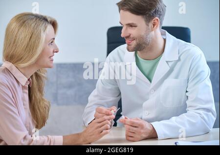 Professionista medico esperto che dà una consultazione al suo paziente Foto Stock
