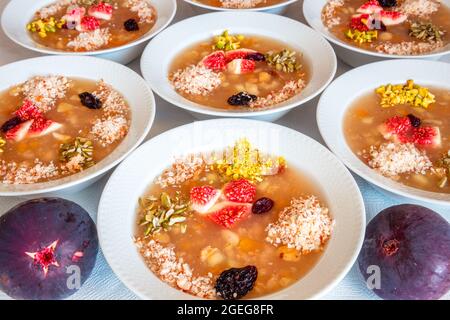 Dessert turco tradizionale ashure, primo piano (Noah's Pudding) è fatto con melograni, cashews, uva, fichi, noci, noci, ceci, fagioli secchi. Foto Stock