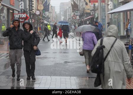 Cork, Irlanda. 20 ago 2021. Shoppers Brave Heavy Rain, Cork, Irlanda. Nonostante le forti e persistenti docce in tutta la contea ribelle questa mattina gli acquirenti hanno ancora sfidato il centro della città oggi. Gli ombrelloni fiancheggiavano le strade della città fino a che l'occhio poteva vedere e alcuni amanti dello shopping hanno persino gustato il pranzo all'aperto sotto alcuni dei molti gazebo sparsi in tutta la città. Credit: Damian Coleman/Alamy Live News Foto Stock