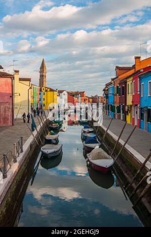 Splendida vista sulle barche e sugli edifici colorati sotto il cielo nuvoloso dell'isola di Burano, Venezia Foto Stock